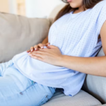 Mulher com desconforto abdominal com má alimentação